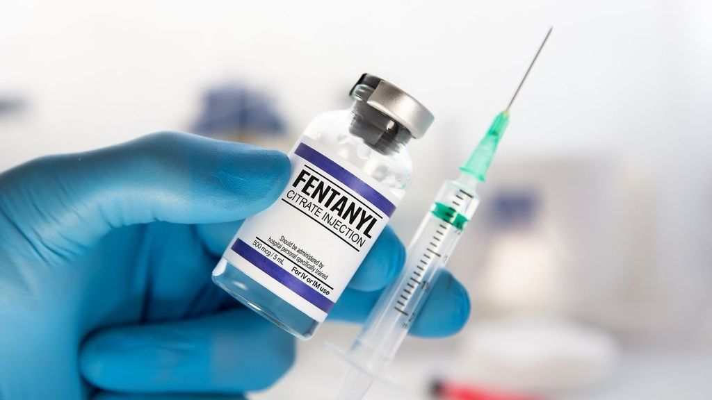 Un profesional sanitario con un vial y una inyección de citrato de fentanilo para tratamiento analgésico