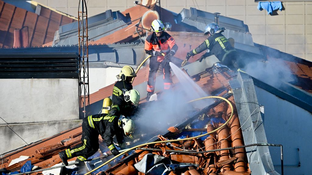 Varios bomberos trabajan en la extinción del incendio de un edificio en Santander