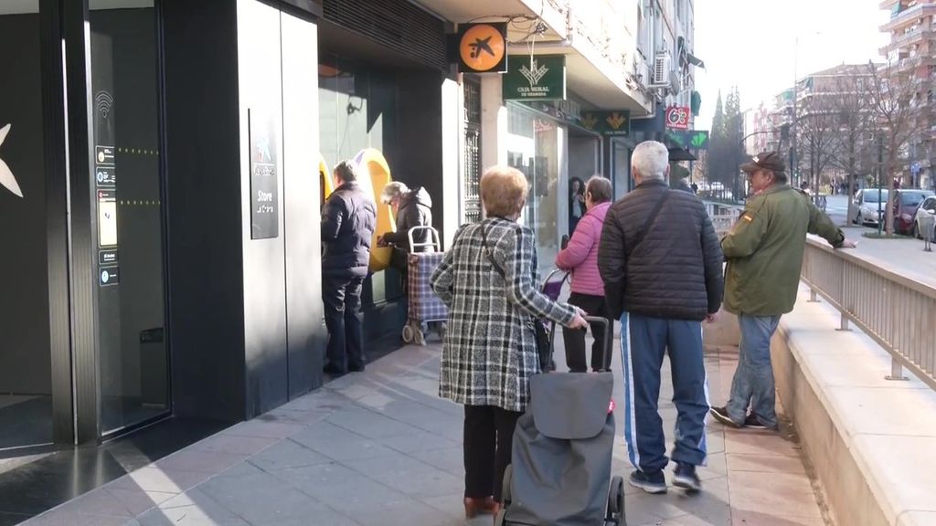 Varios pensionistas hacen cola ante una sucursal bancaria para comprobar lo cobrado este mes de enero en su pensión