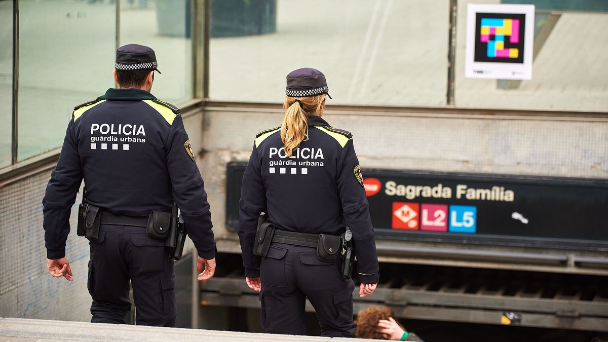 Dos agentes de la Guardia Urbana en el acceso al Metro de Sagrada Familia en Barcelona