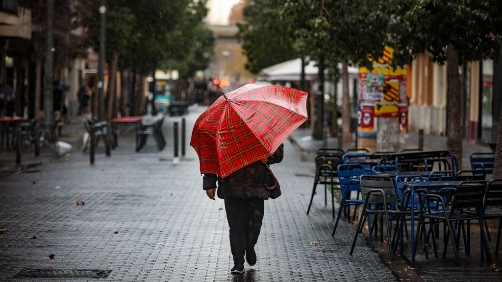 Una mujer con el paraguas bajo la lluvia