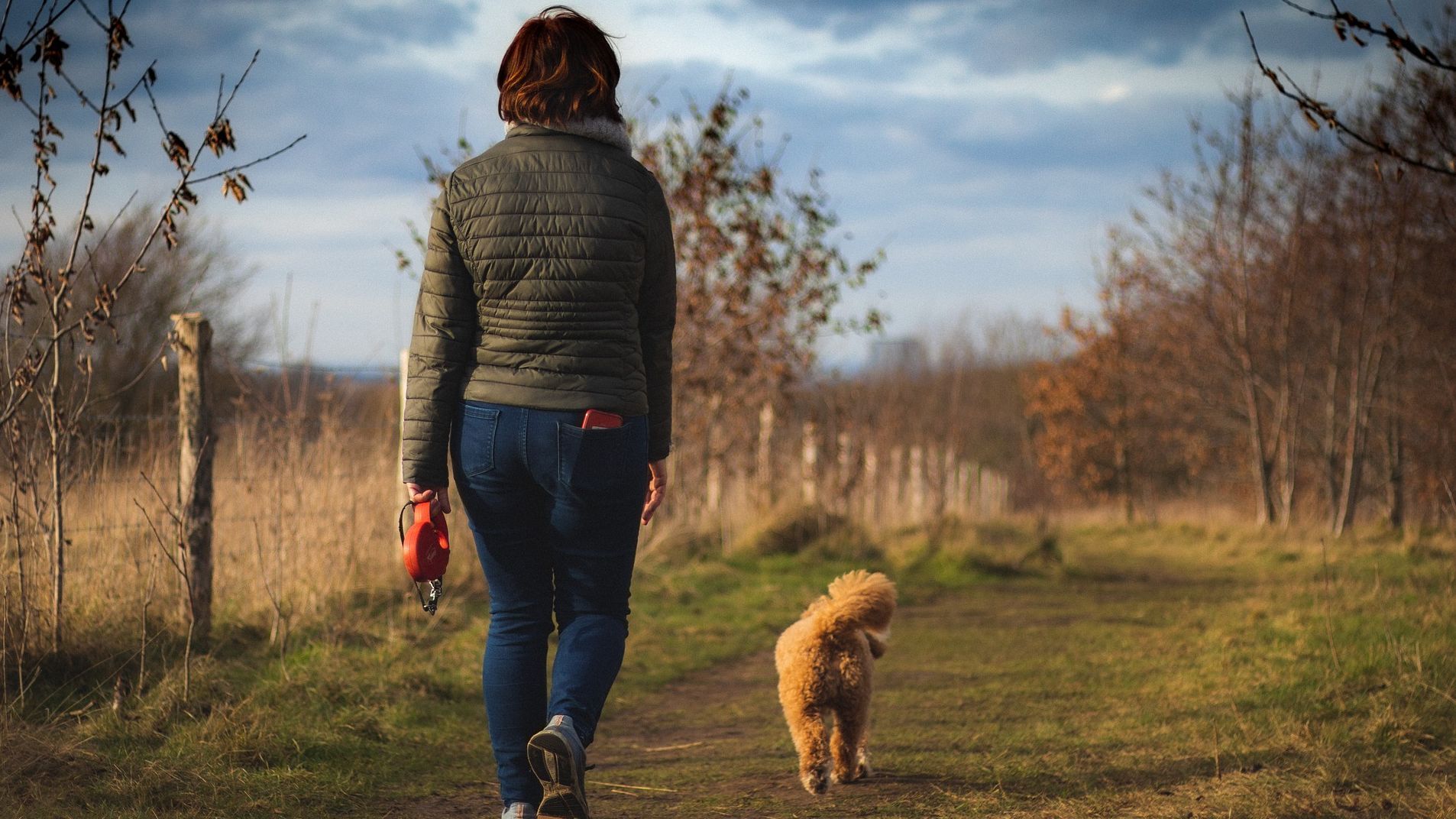 Una mujer aprovecha para hacer pasos mientras sacar a pasear a su perro