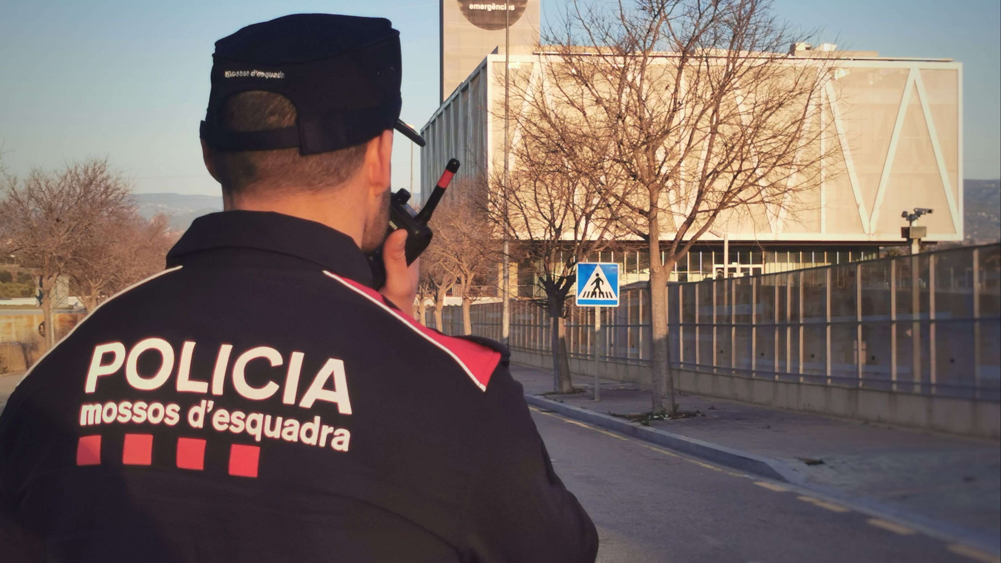 Un agente de los Mossos frente al edificio del 112 de Emergencias