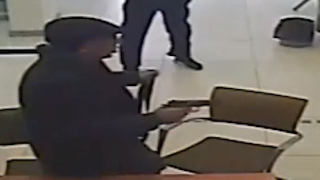 Atracador con un arma apuntando a otra persona
