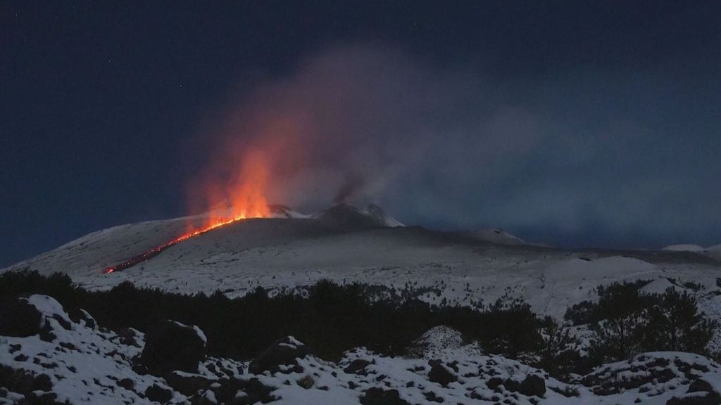 La cumbre nevada del monte Etna, en Sicilia, Italia, se ha visto sacudida por una erupción que ha arrojada lava en el cráter de 'Boca Nueva'