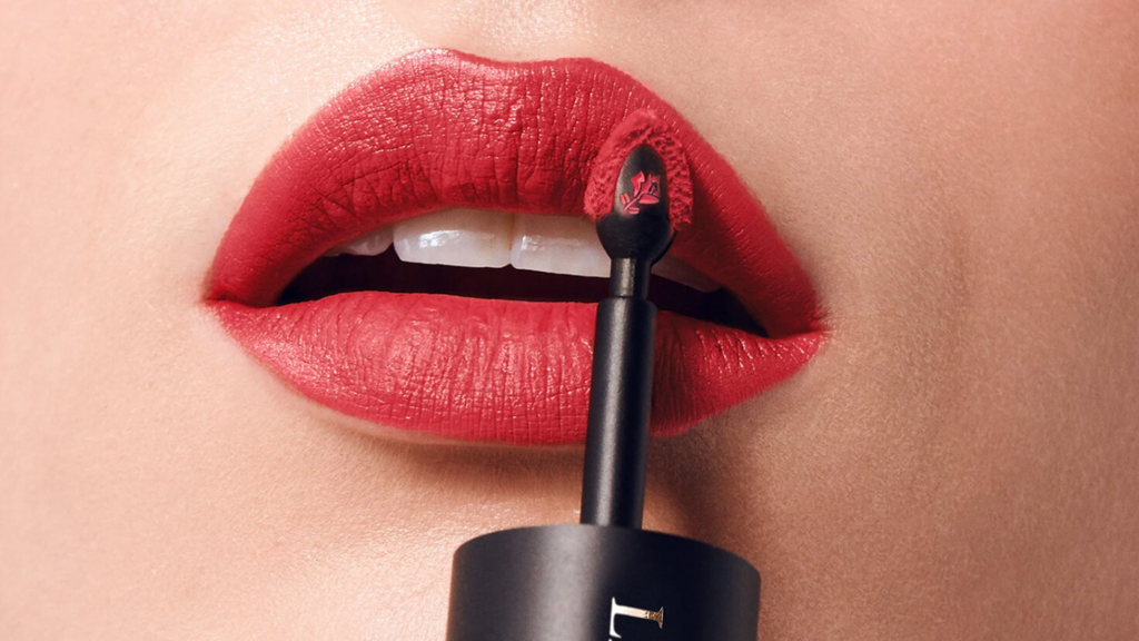 Modelo maquillándose los labios con L'Absolue Rouge Drama Ink