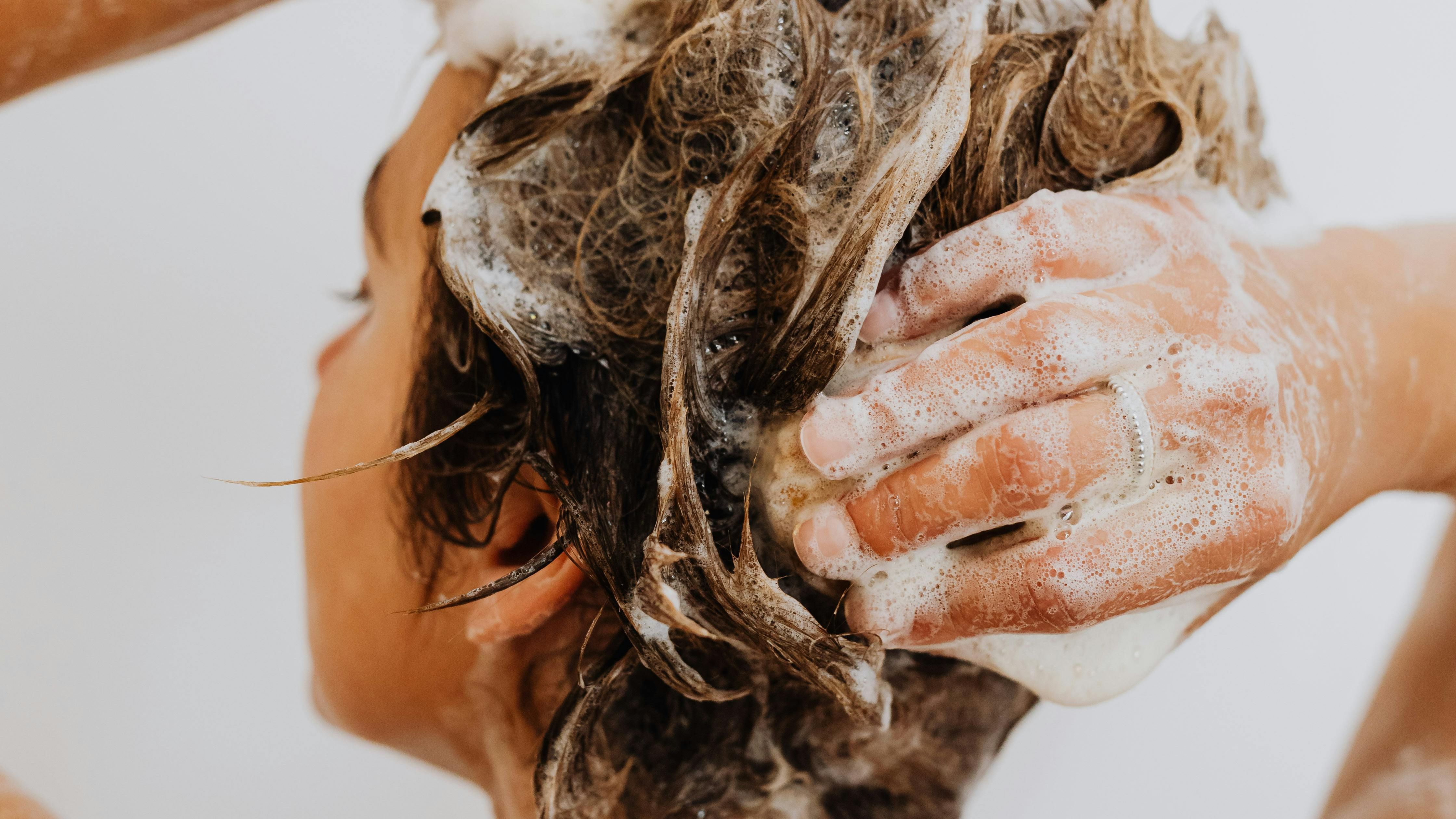 Mujer enjabonándose el pelo
