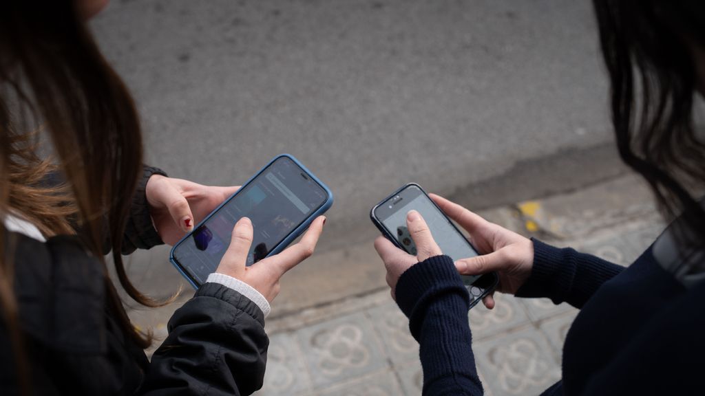 Dos personas usan el teléfono móvil, a 1 de febrero de 2024, en Barcelona, Catalunya (España).