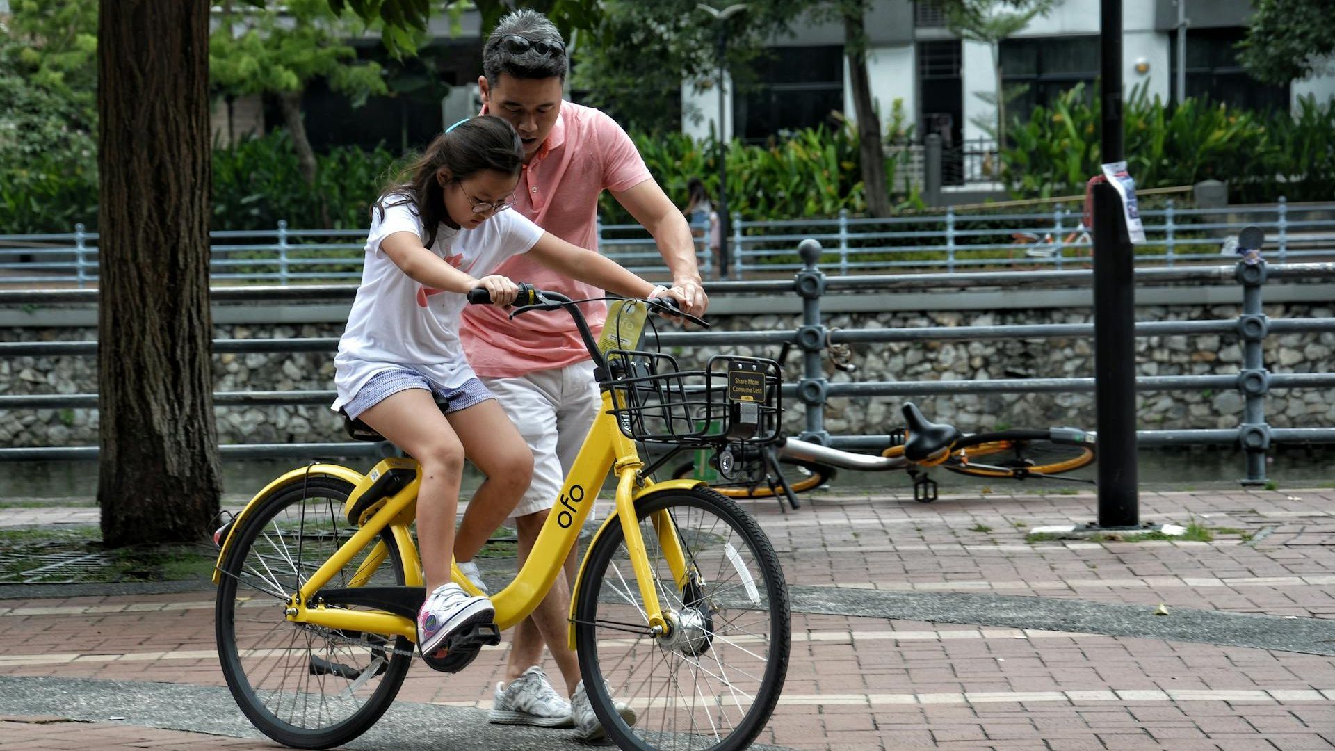 Un padre enseña a montar en bicicleta a su hija