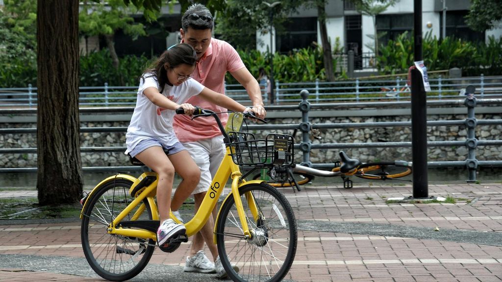 Un padre enseña a montar en bicicleta a su hija