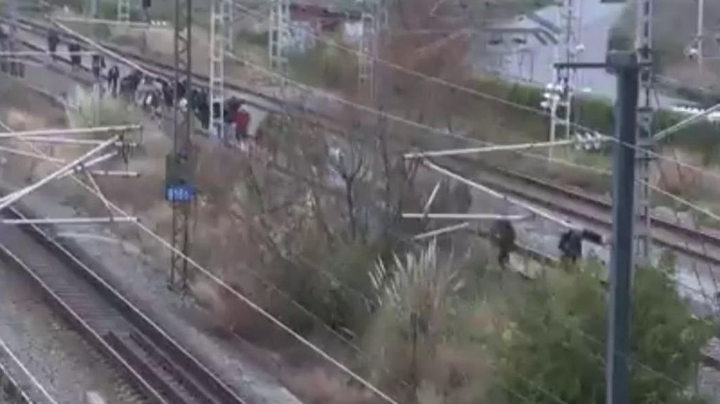 Pasajeros evacuados caminando por las vías.