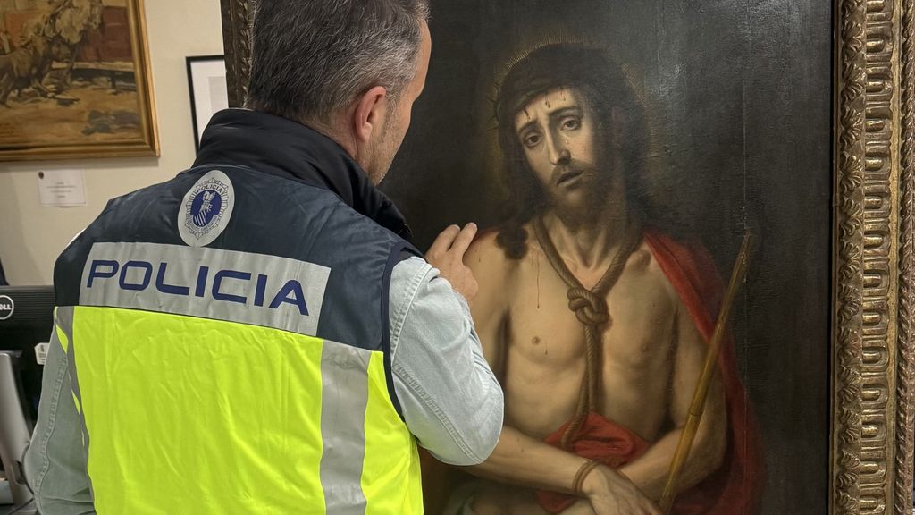 Agente junto al cuadro intervenido por no ser del autor que se decía