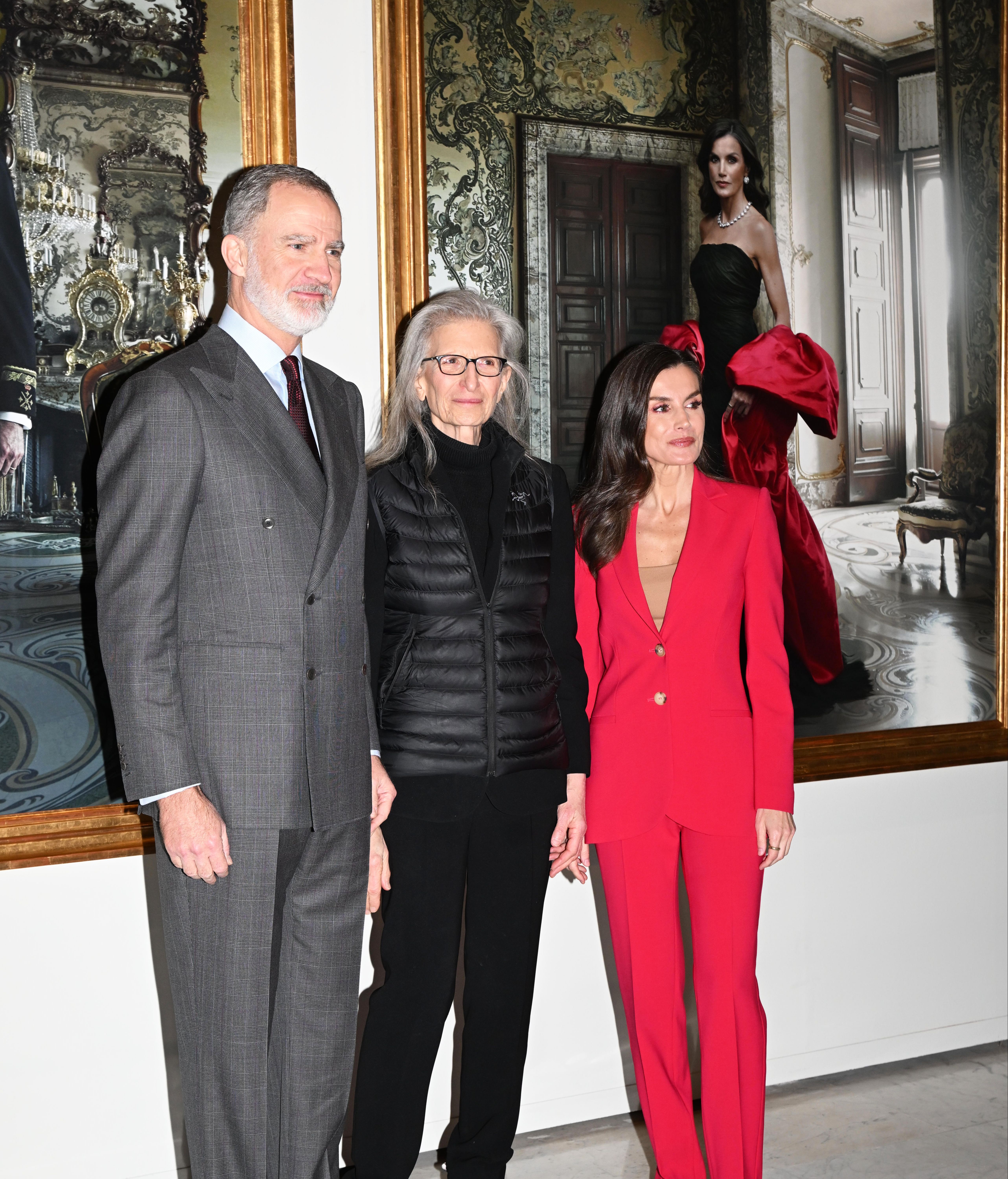 Annie Leibovitz con los reyes Felipe y Letizia junto a sus retratos.