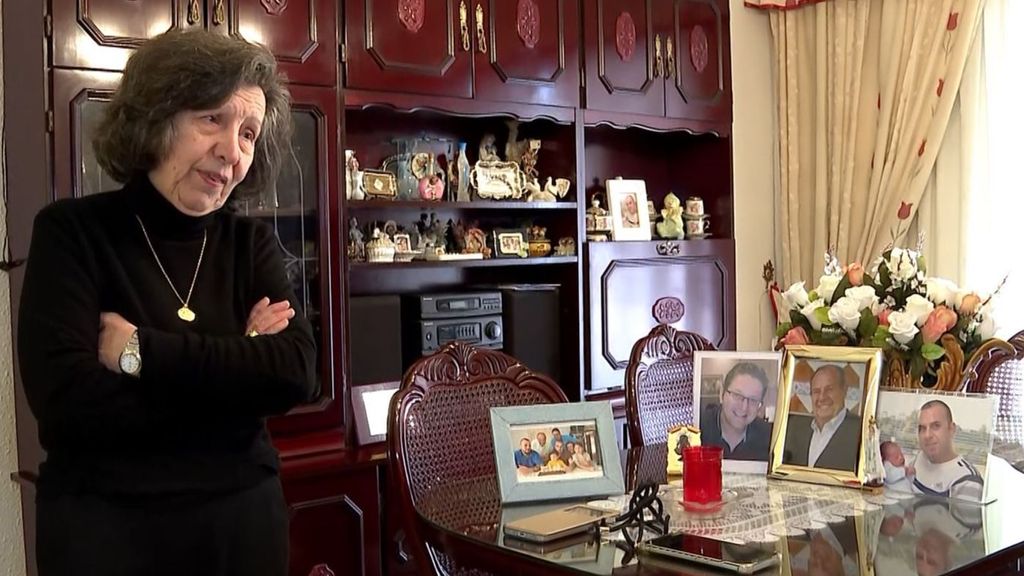 Dolores en el salón de su casa junto a las fotos de sus hijos y su marido