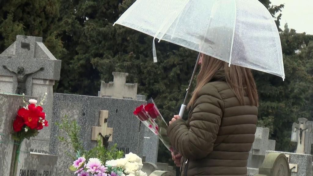 María Villanueva Sanz deja una rosa en las tumbas de sus padres.