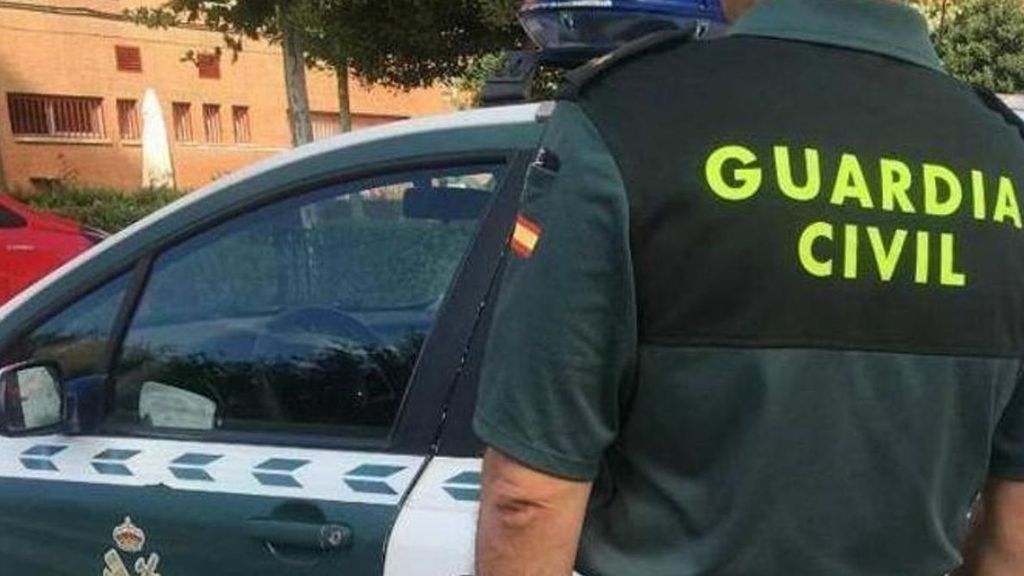 Un agente de la Guardia Civil junto a su vehículo