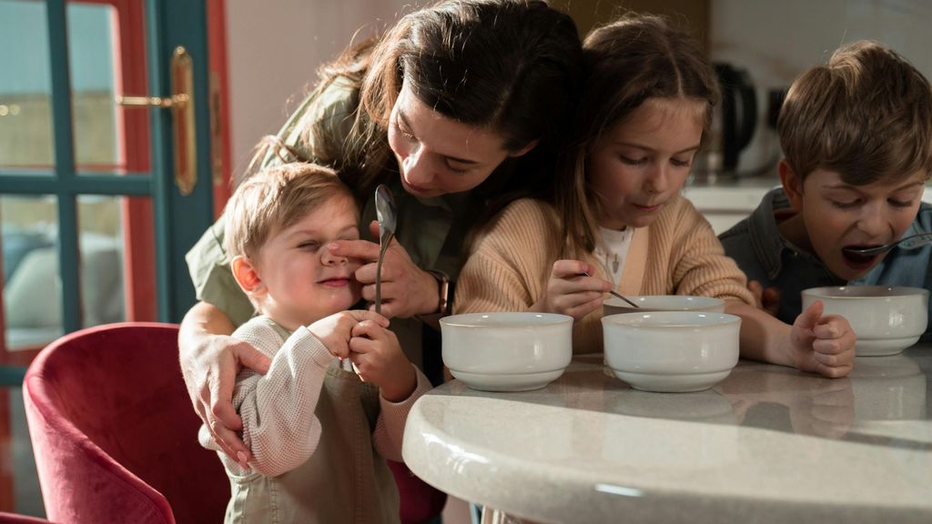 Madre dando de comer a sus hijos