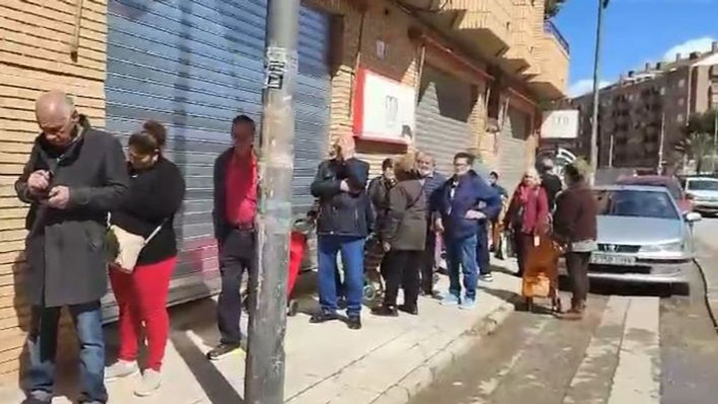 Decenas de vecinos afectados por las inundaciones hacen cola para recibir alimentos