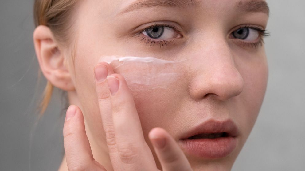 Mujer aplicándose crema en la cara