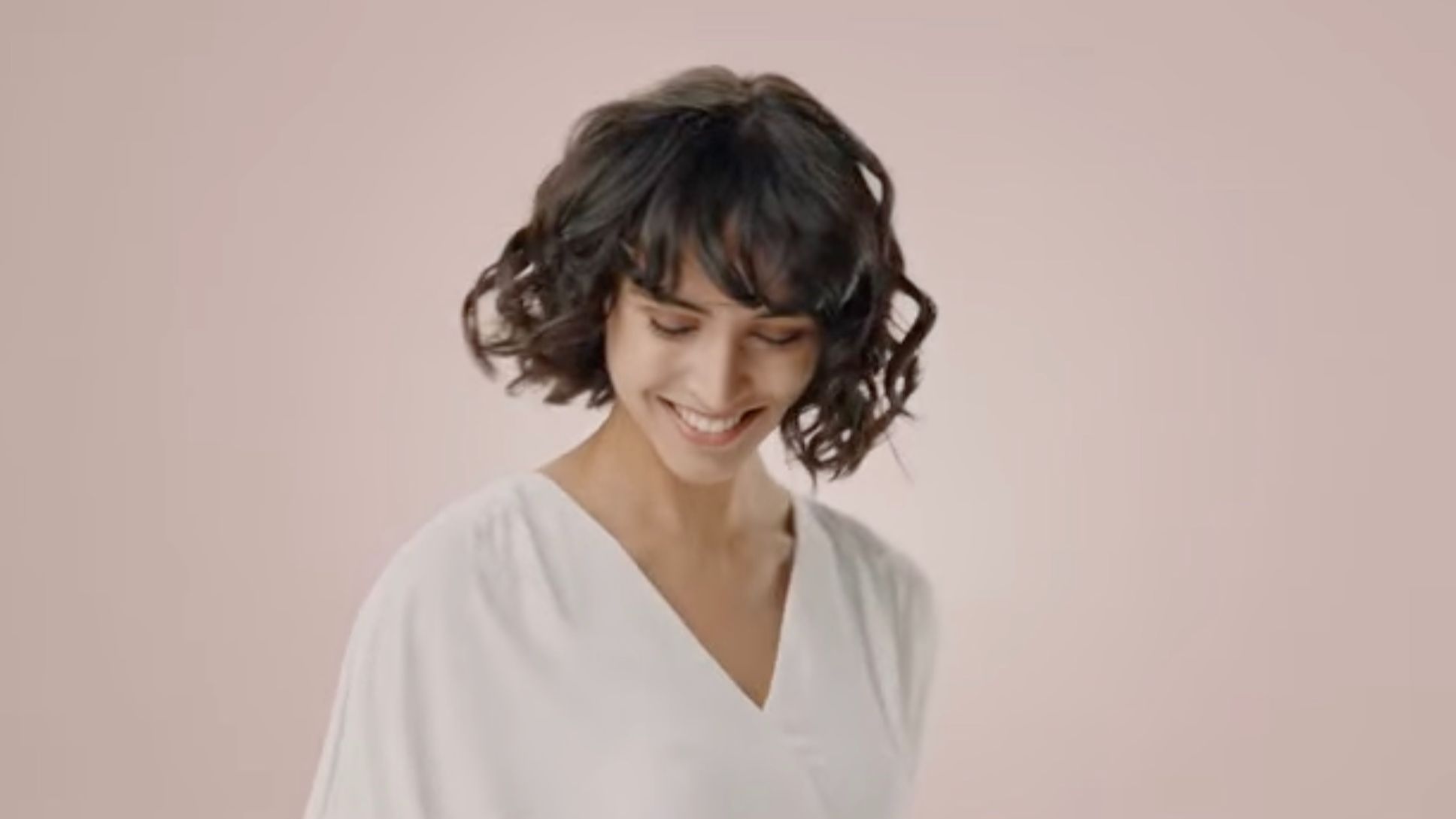 Modelo con el cabello ondulado con el Dyson Airwrap para cabello liso