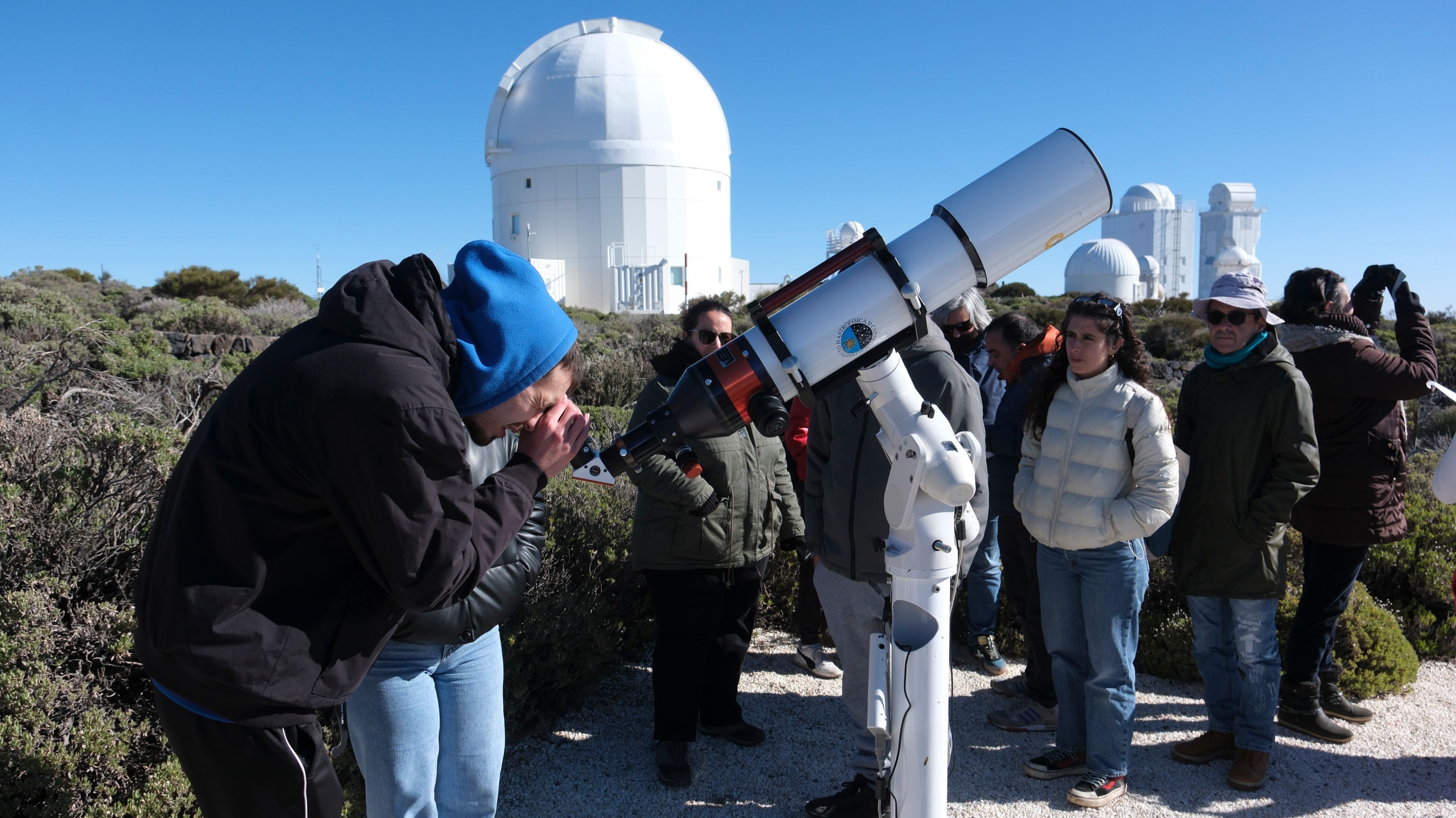 Un grupo de personas observa el eclipse parcial de sol este sábado desde el Observatorio del Teide