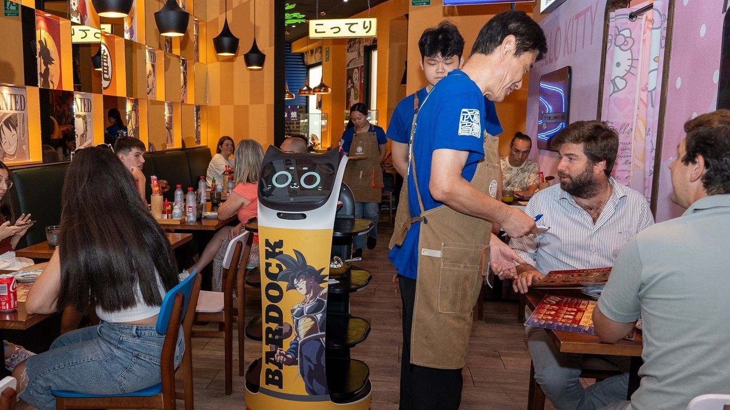 Un gato robot que ayuda a servir comida en un restaurante de Sevilla.
