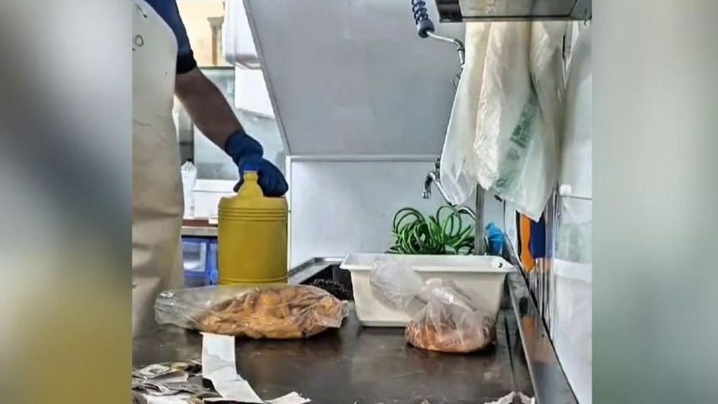 Un hombre lava con lejía carne en mal estado.