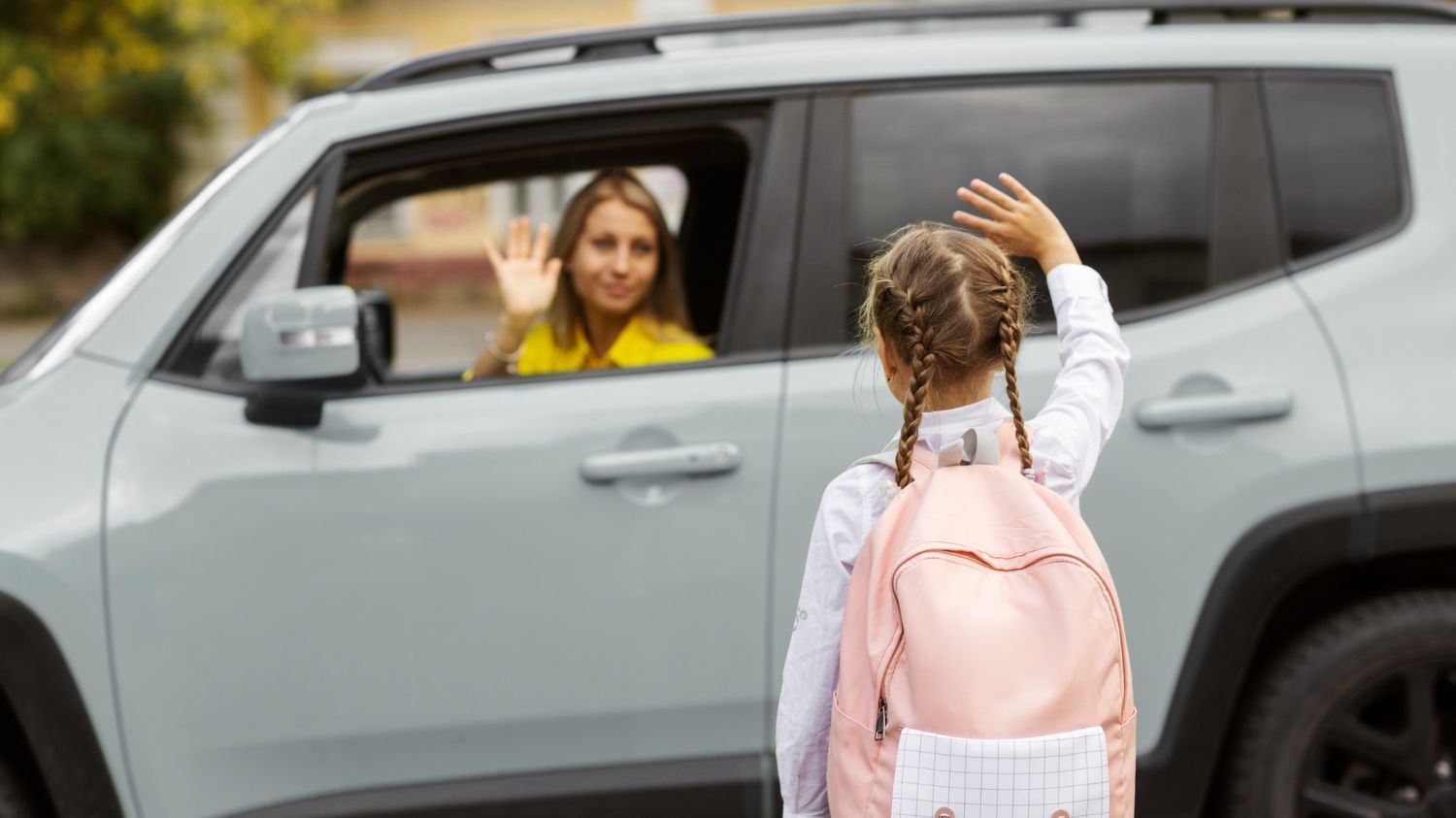 Una madre despidiéndose de su hija antes de entrar a la escuela