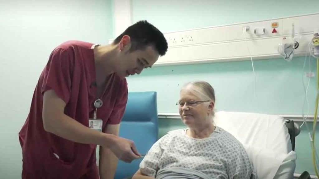 Un enfermero ayuda a una paciente en un hospital de Reino Unido.