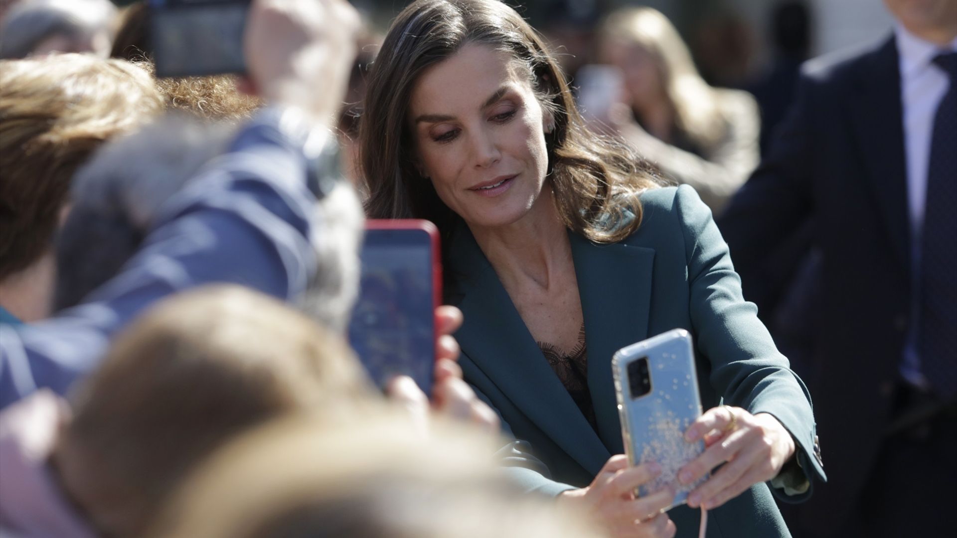 La Reina Letizia ayudando a una fan a hacerse un selfie en León