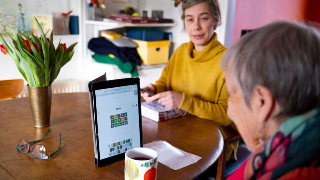 Una anciana diagnosticada de Alzheimer hace ejercicios de memoria bajo la supervisión de su hija.