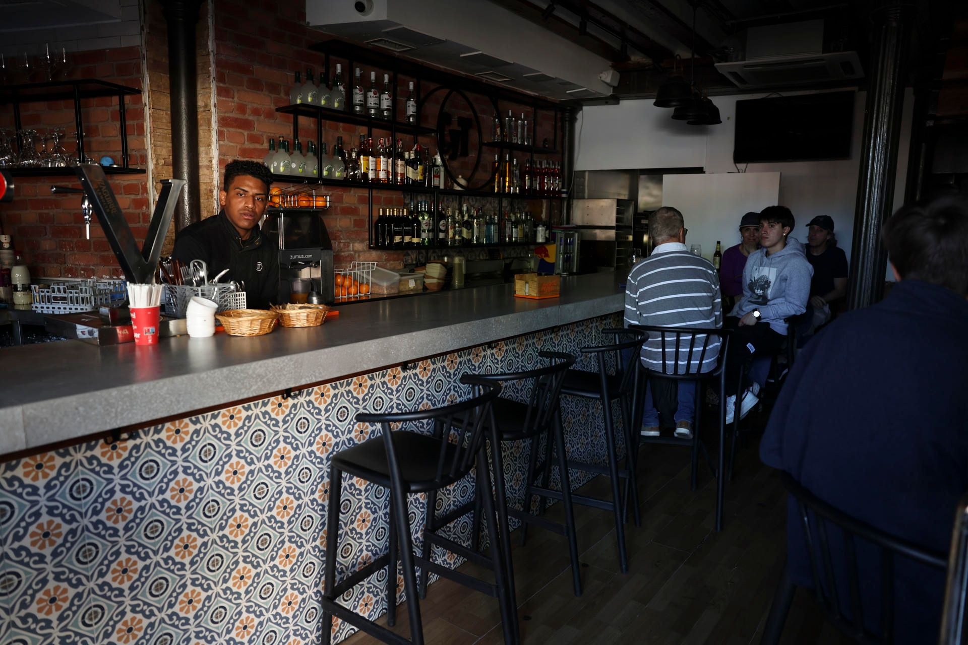 Un bar, con clientela y la luz apagada