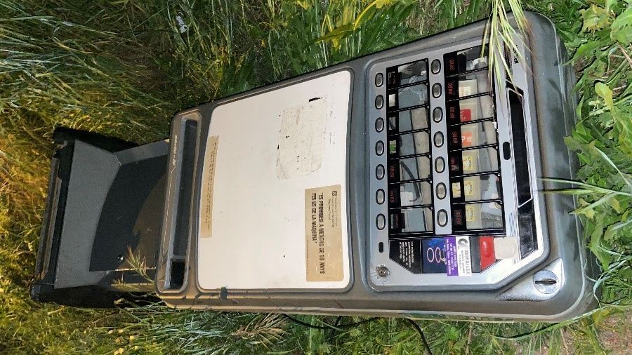 La máquina de tabaco de un bar, entre matorrales