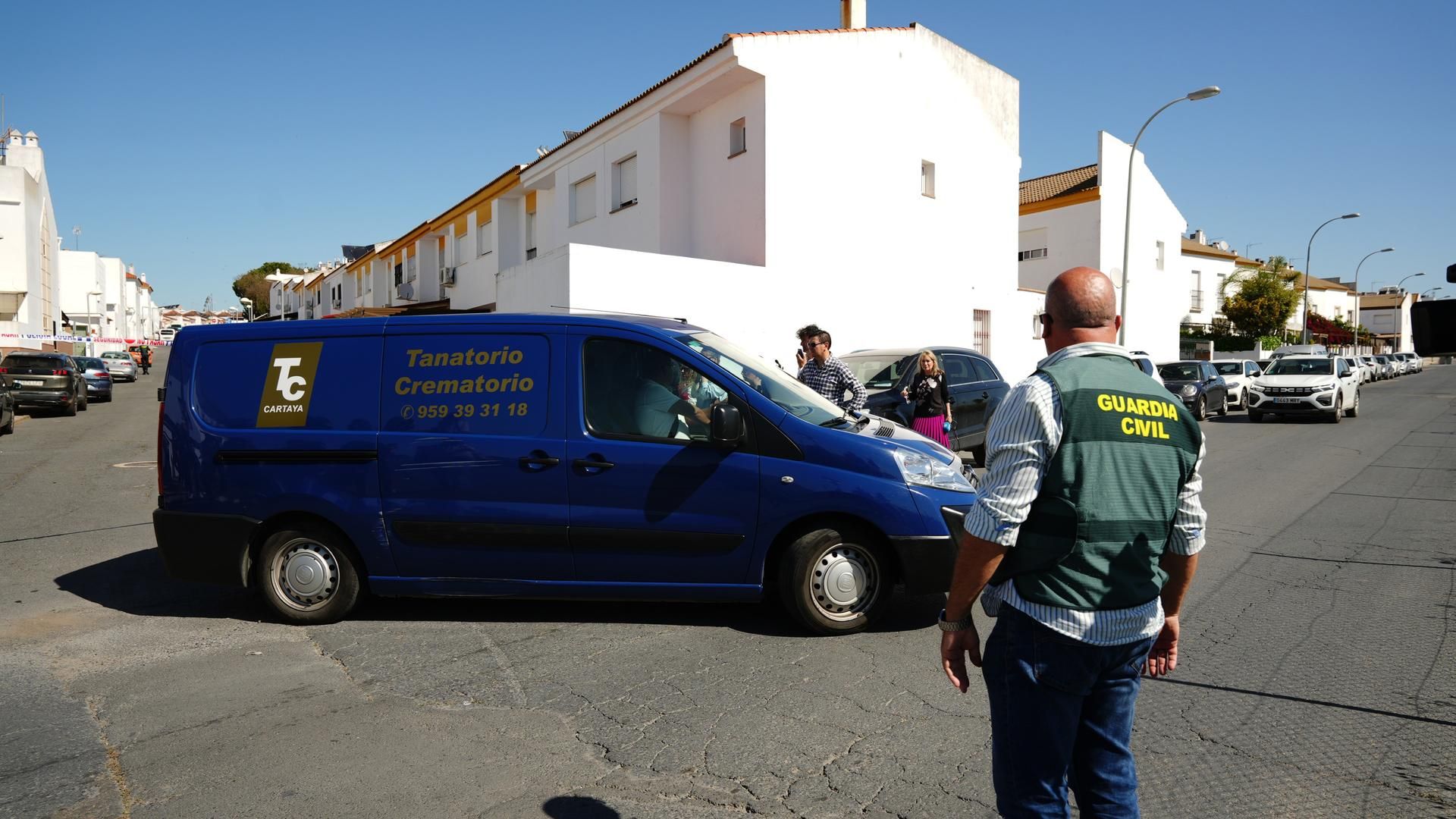 Un coche fúnebre llega a la zona de la vivienda de la mujer muerta de forma violenta en Cartaya (Huelva).