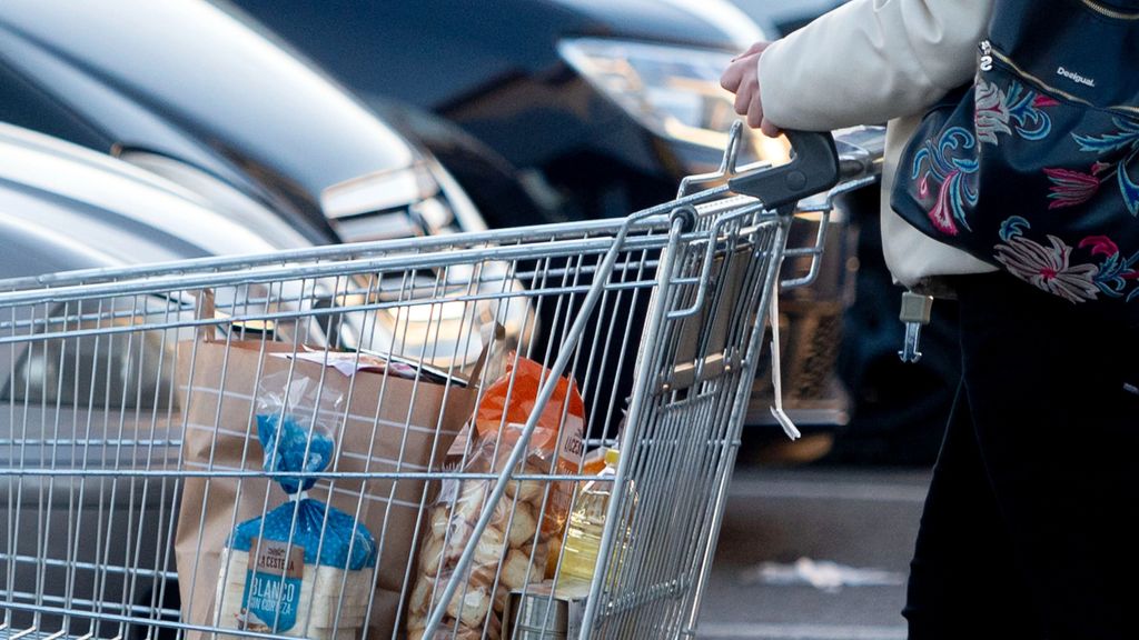 una mujer sale de un supermercado con un carro de la compra 80b1