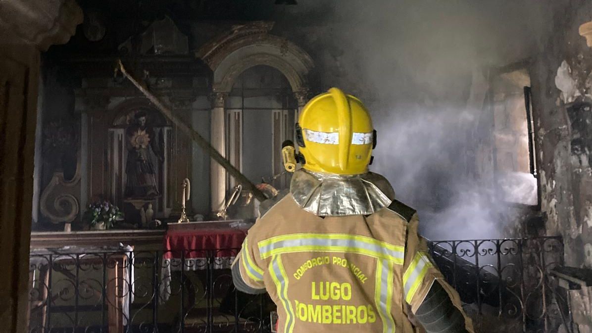 Un bombero trabajando en el incendio de la iglesia de San Xiao de Carballo, en Friol
