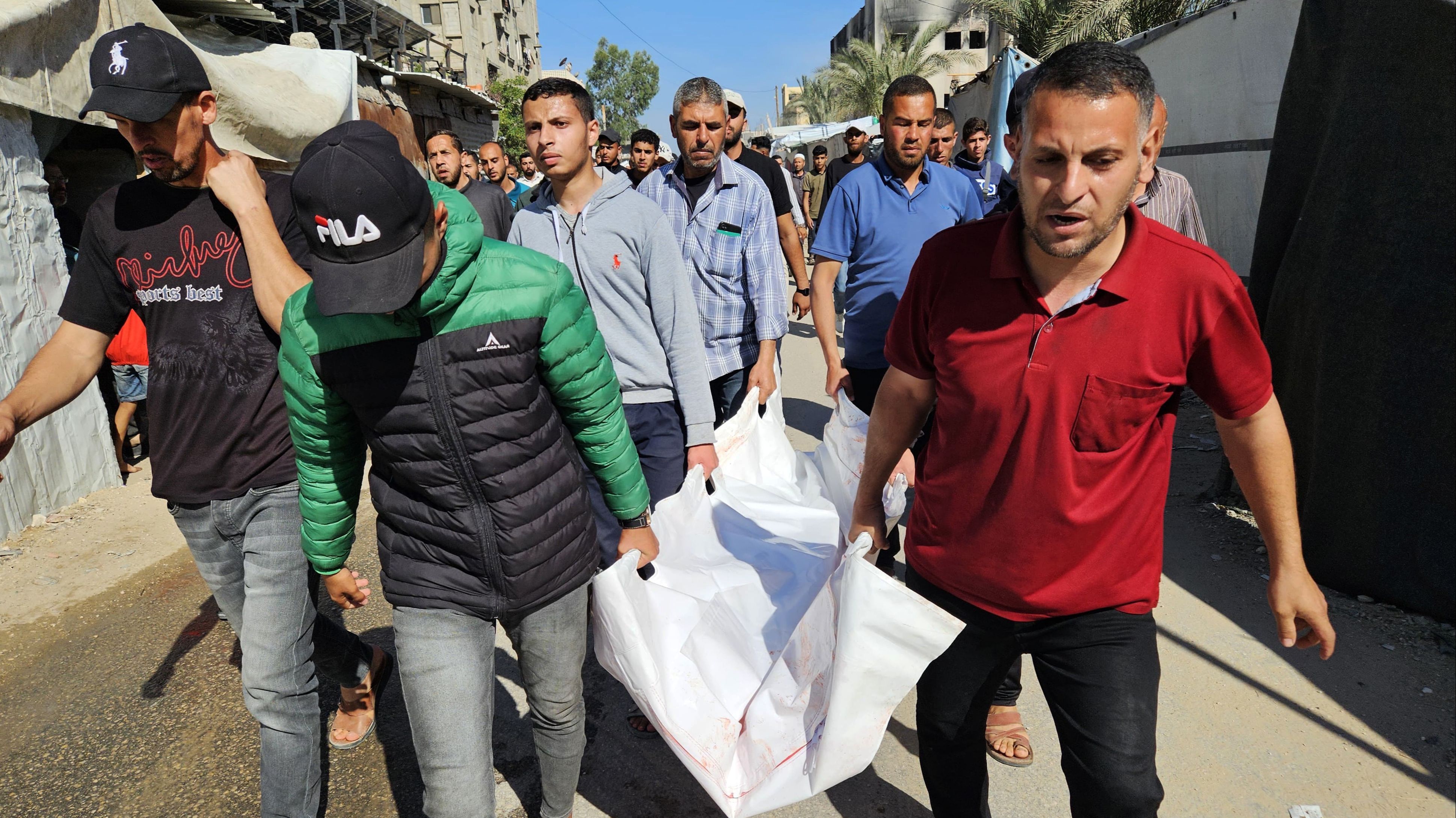 Un grupo de personas trasladan el cuerpo de una víctima de los ataques israelíes sobre Gaza
