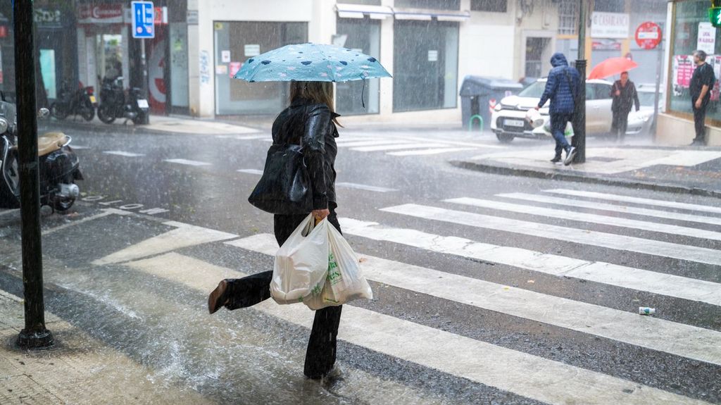 Varias personas caminan bajo la lluvia