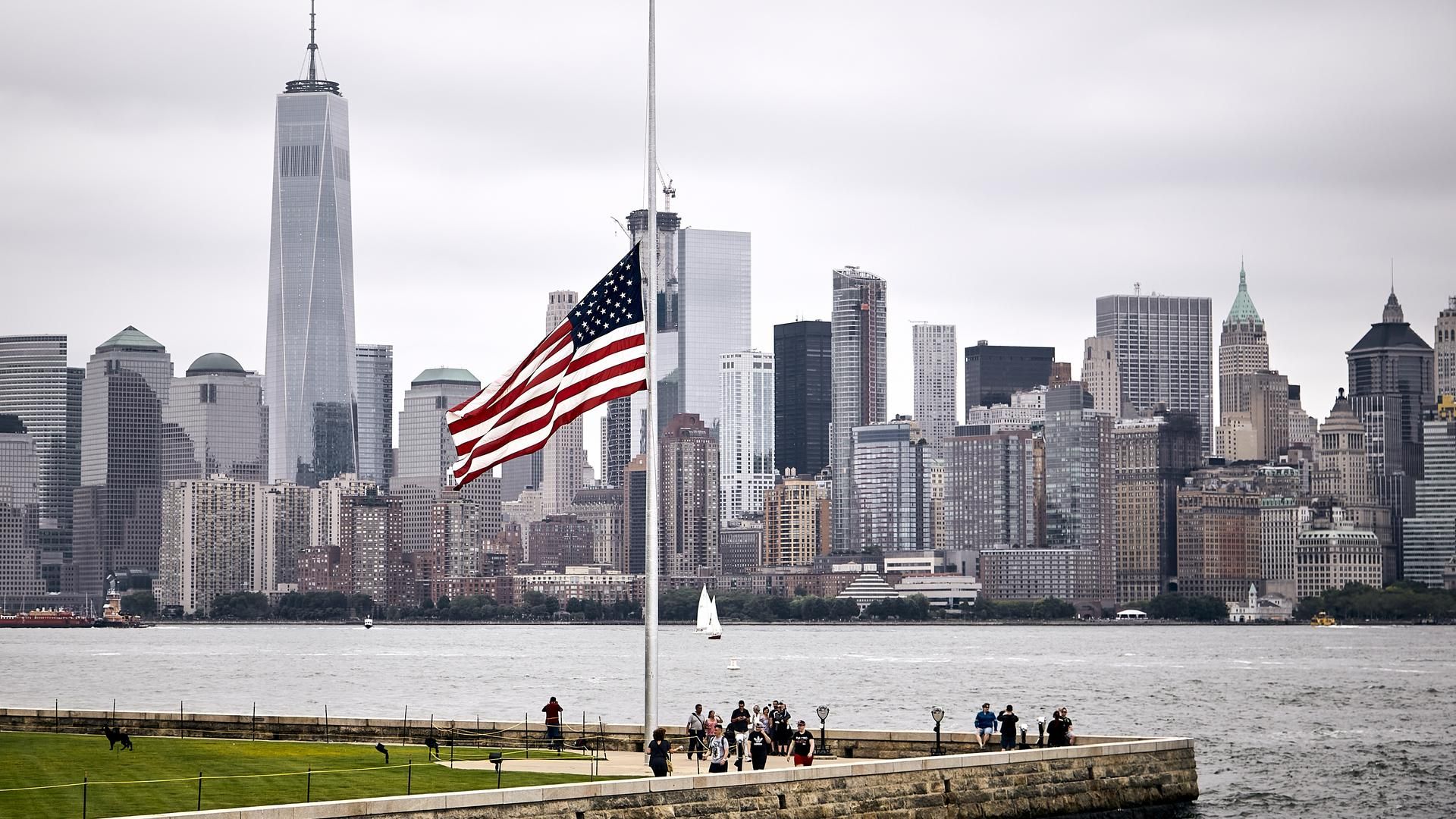 increible foto de la bandera estadounidense en un parque en el fondo del horizonte de manhattan