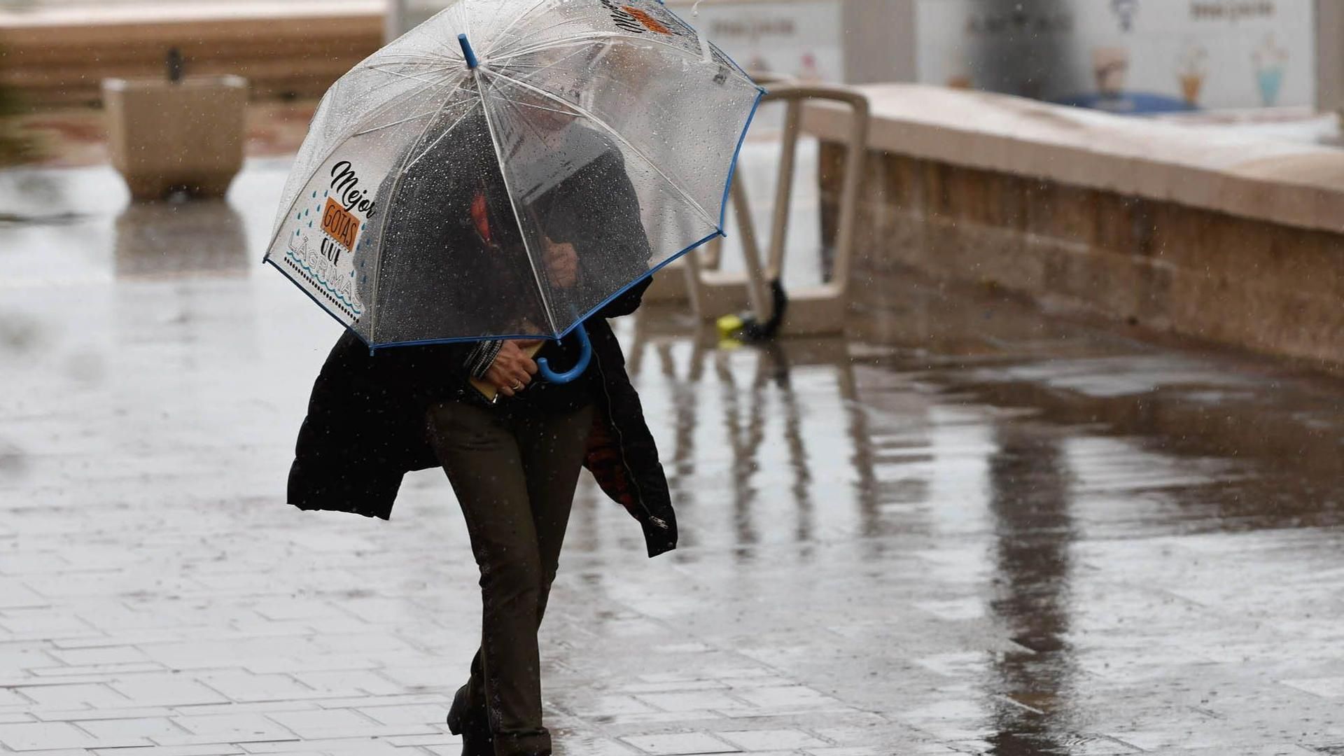 Una persona se resguarda con un paraguas de la lluvia que cae en Almería Una persona se resguarda con un paraguas de la lluvia que cae en Almería