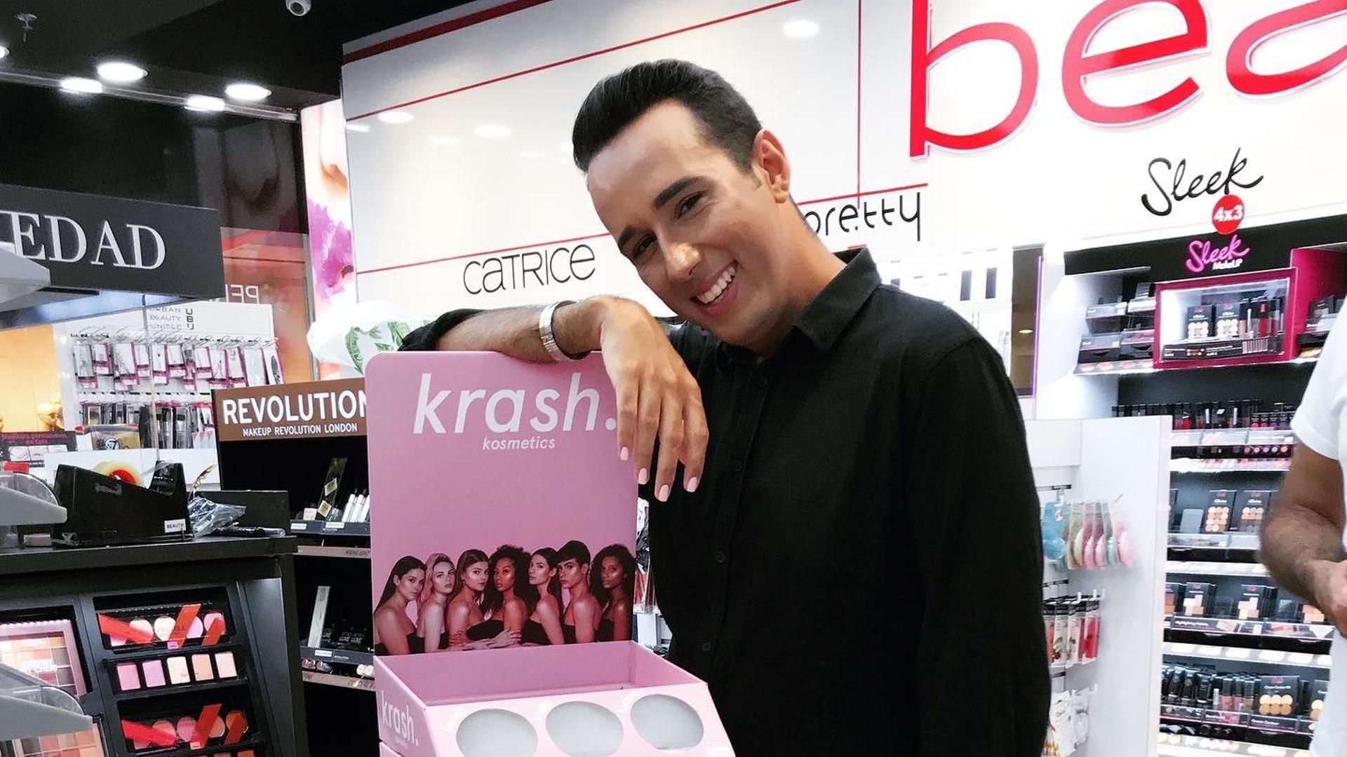 Alvaro Kruse porsando con un stand de su marca