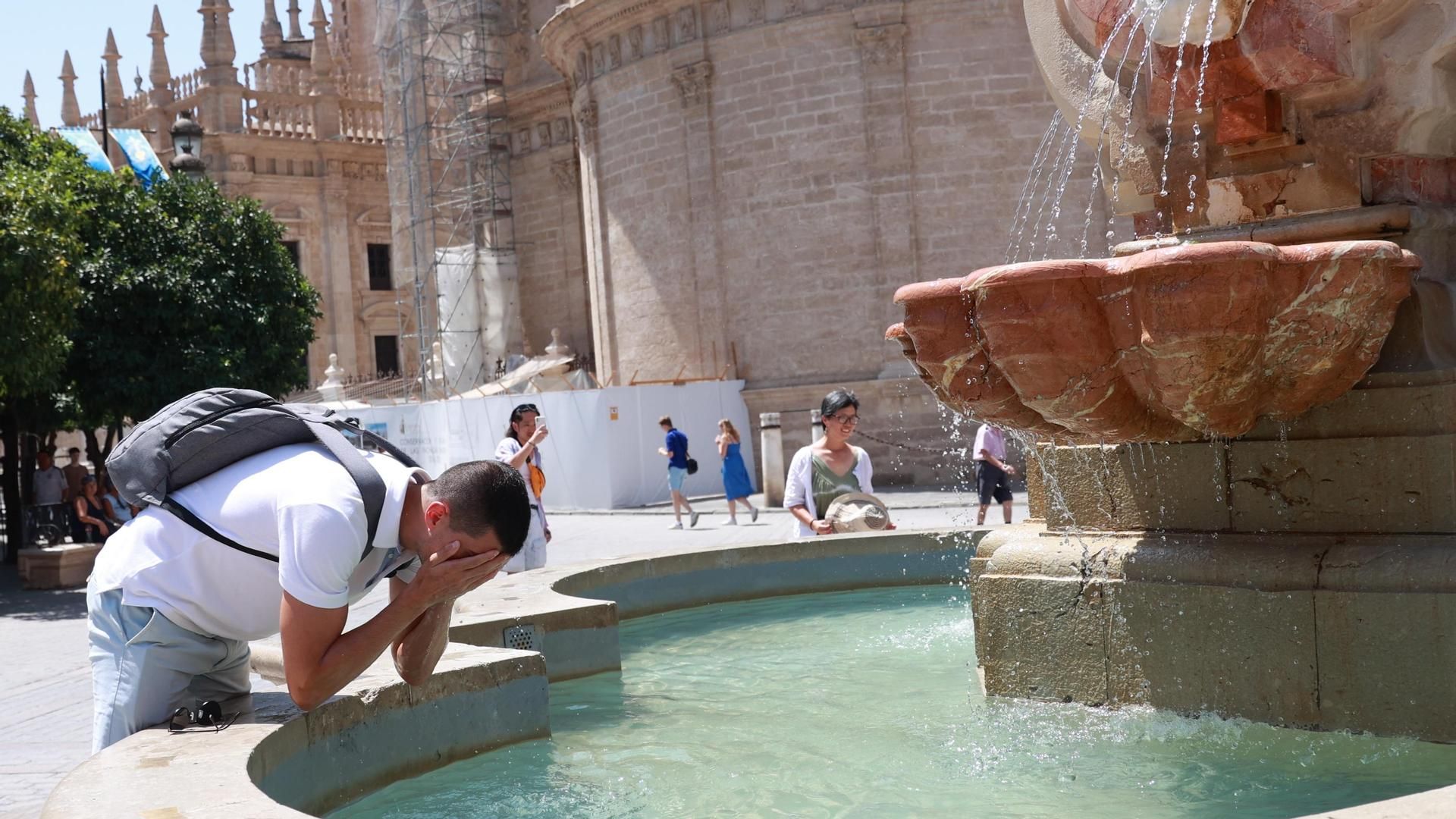 Imagen de archivo de un joven refrescándose en una fuente para soportar las altas temperaturas en Sevilla Imagen de archivo de un joven refrescándose en una fuente para soportar las altas temperaturas en Sevilla