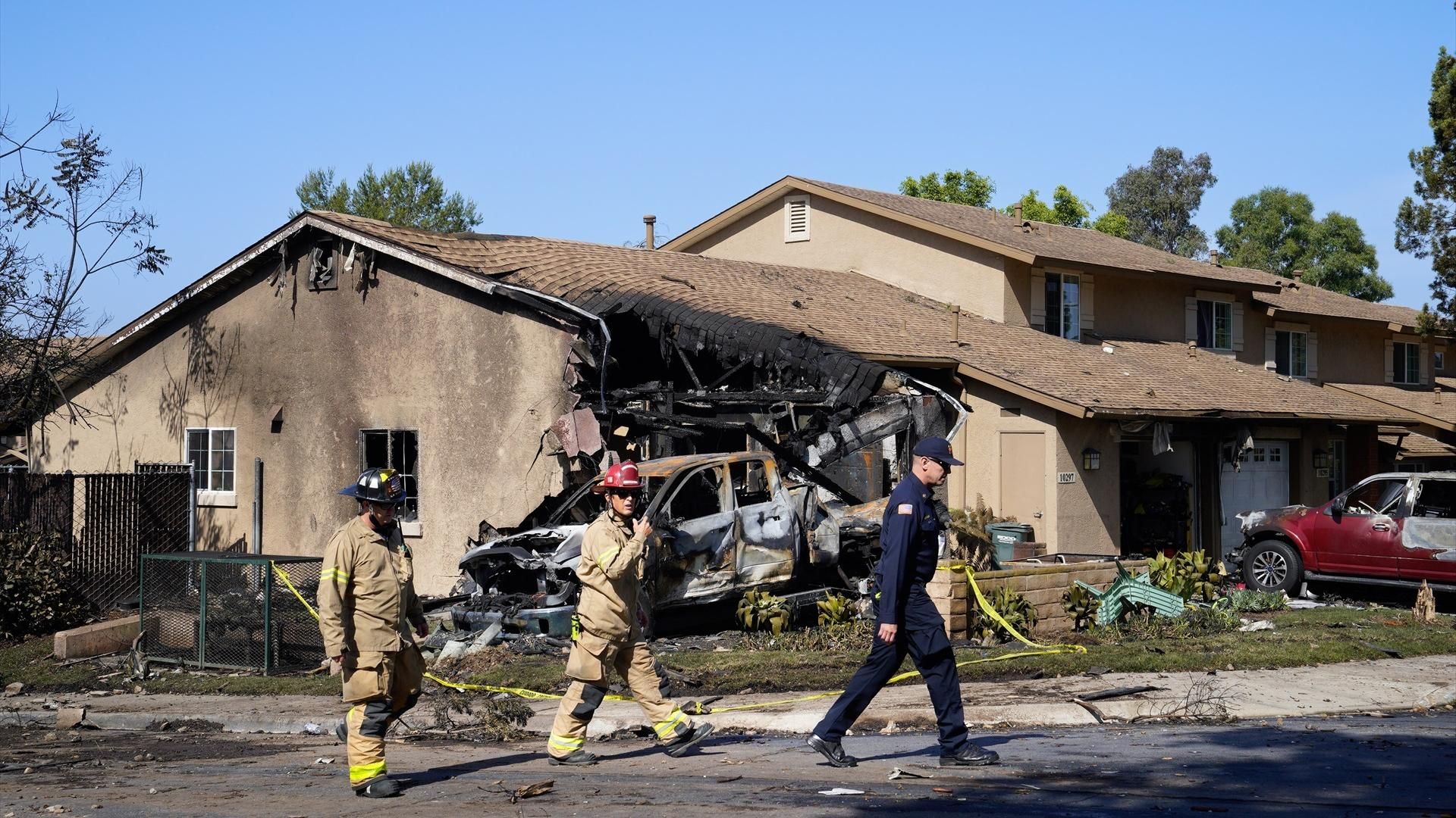 El personal de emergencia estadounidense camina dentro del lugar del accidente acordonado en Sample Street en Murphy Canyon