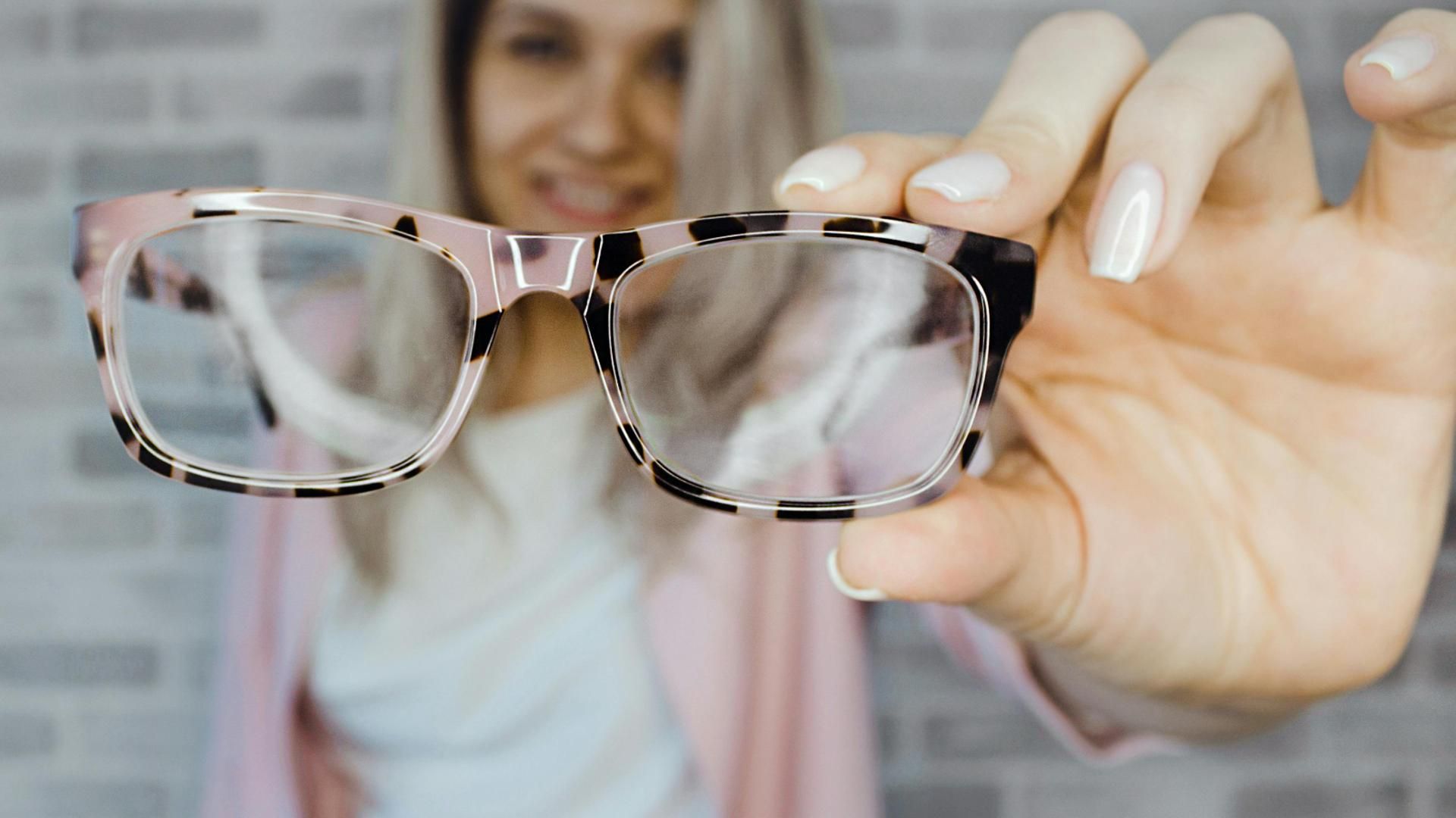 Una mujer joven mostrando unas gafas de ver