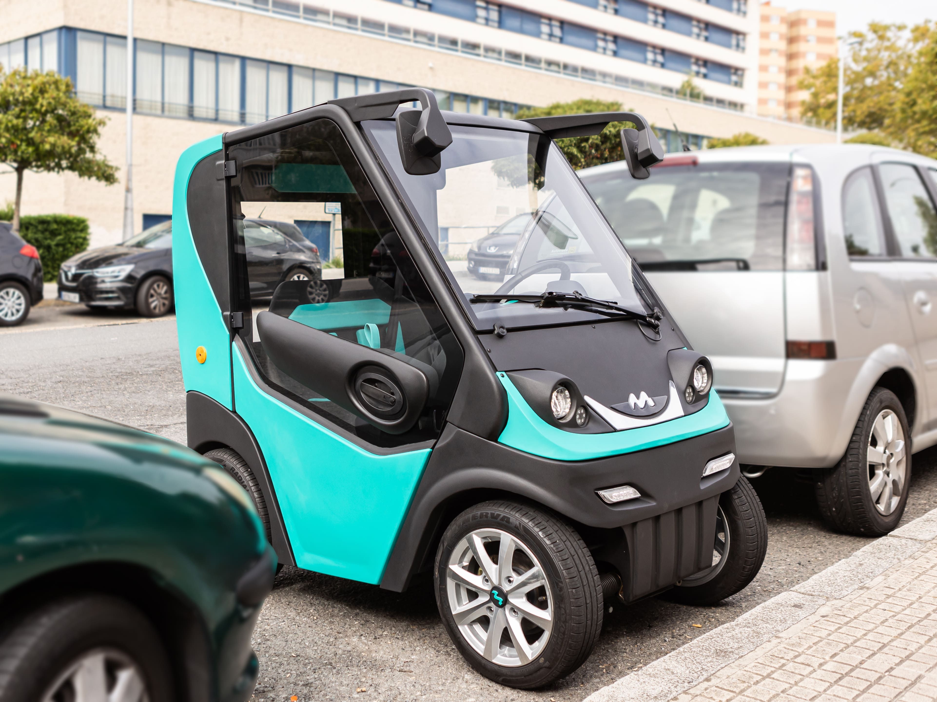 El microcoche "Neno" aparcado entre dos vehículos