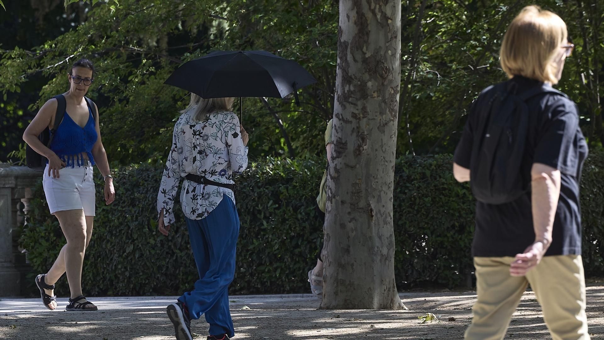 Ciudadana se protege del sol en el parque del Retiro