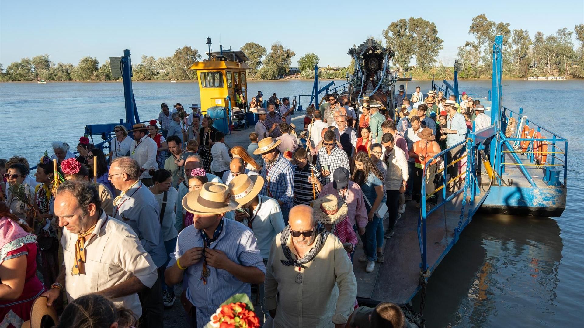 La hermandad rociera de Carmona desembarca de la barcaza de Coria del Río en la Romería del pasado año
