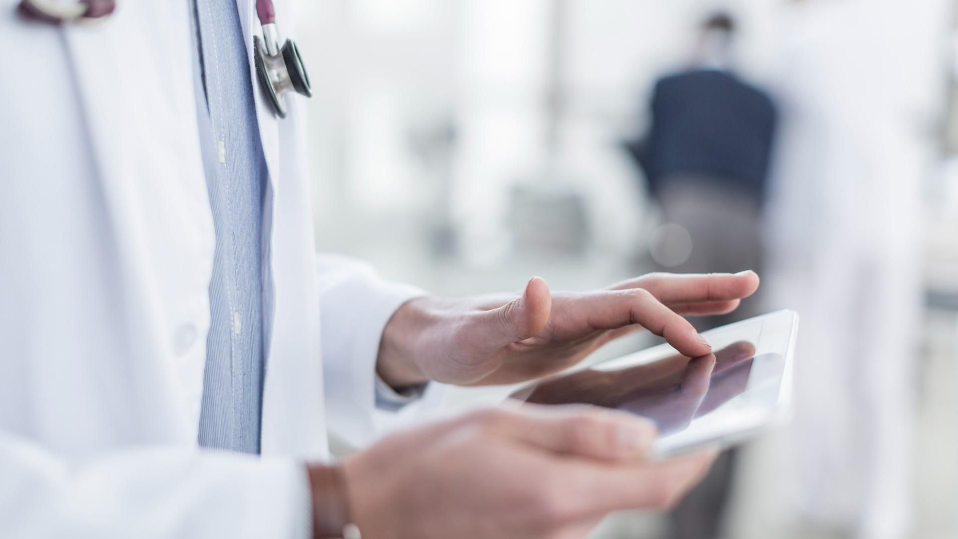 Un médico consulta un dispositivo móvil