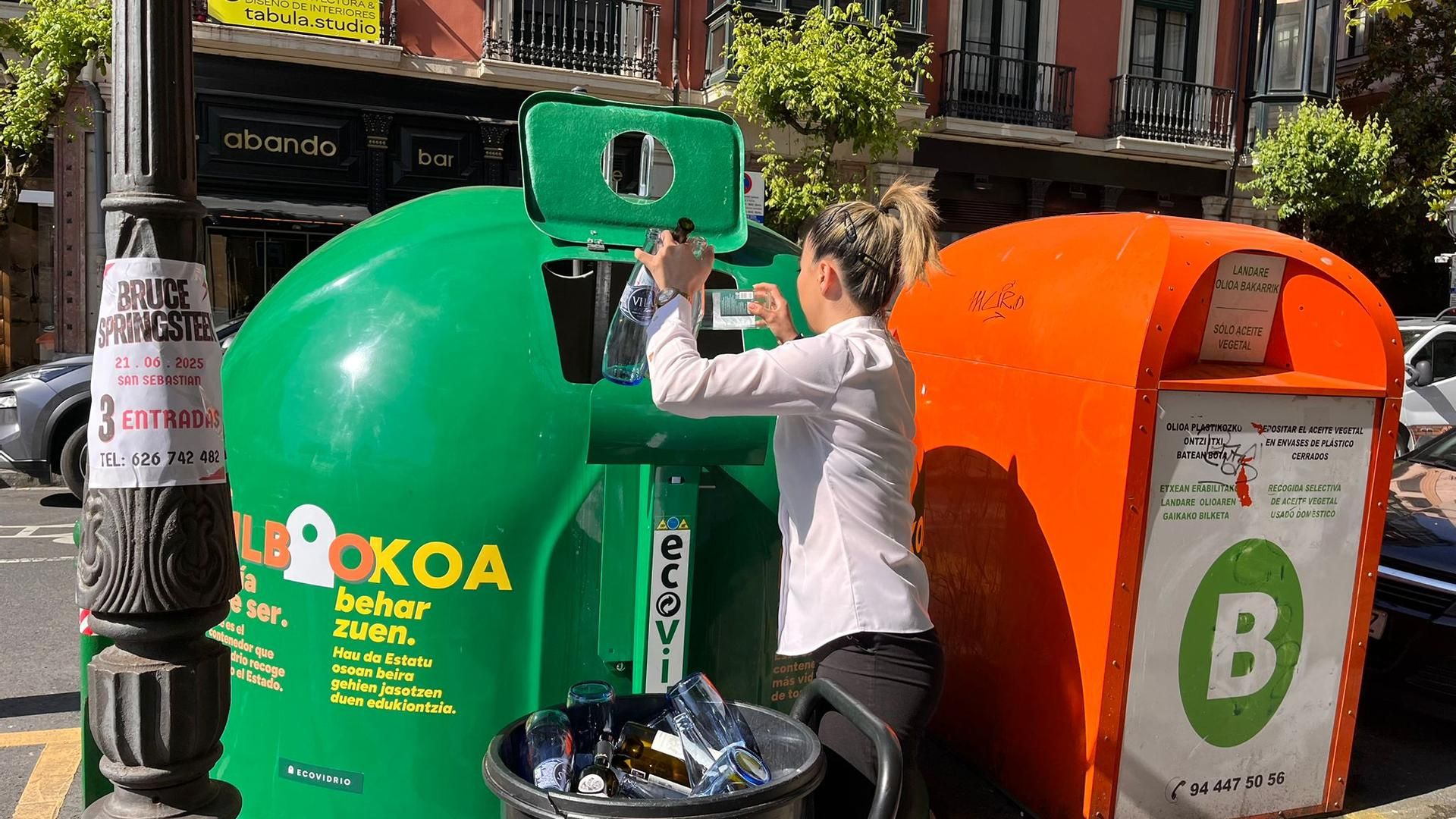 Una mujer deposita envases de vidrio en el contenedor verde de la Plaza del Ensanche, en Bilbao esta mañana Una mujer deposita envases de vidrio en el contenedor verde de la Plaza del Ensanche, en Bilbao esta mañana