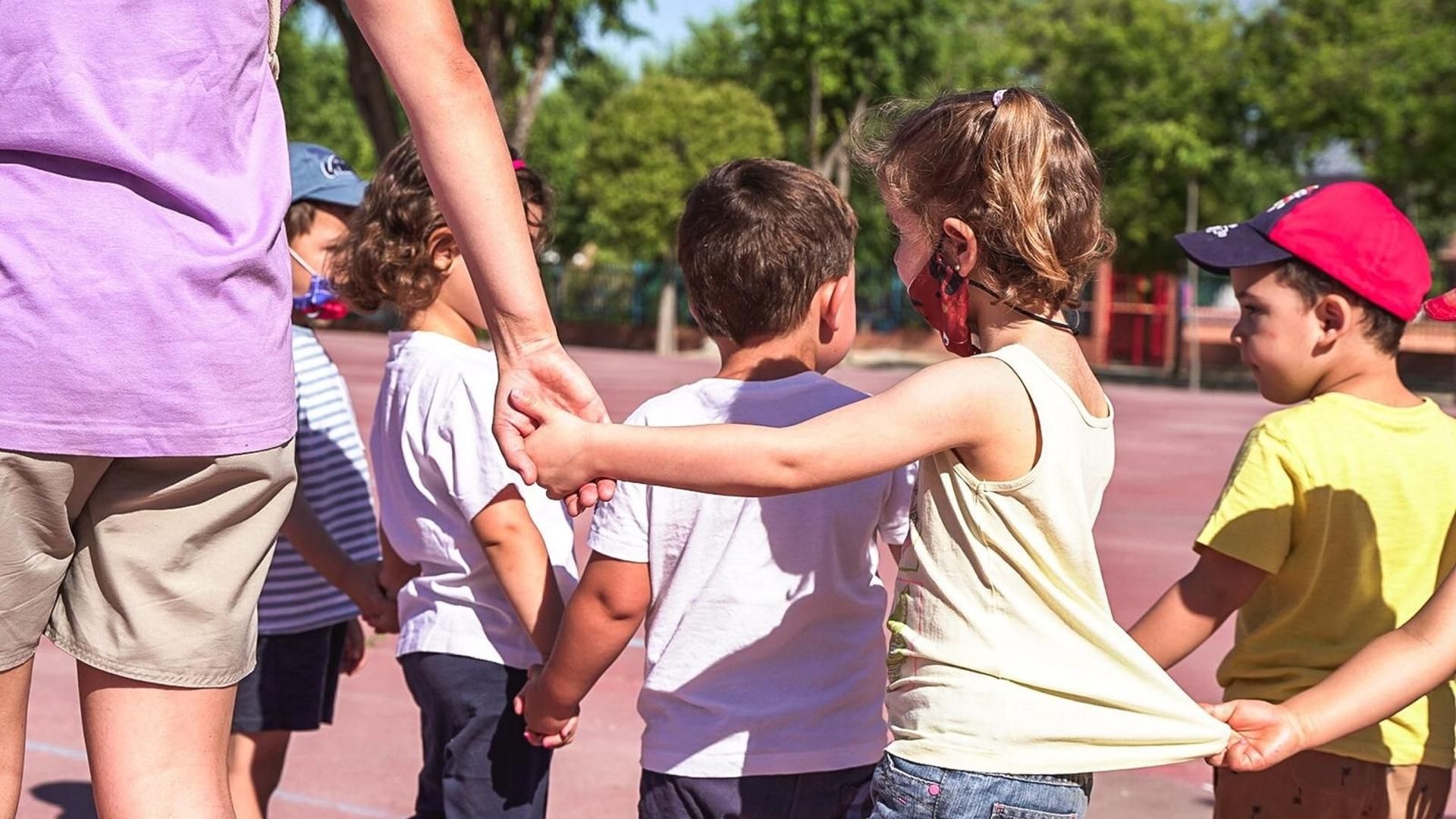 Un grupo de niños juega acompañados por una monitora en Colmenar, Madrid Un grupo de niños juega acompañados por una monitora en Colmenar, Madrid